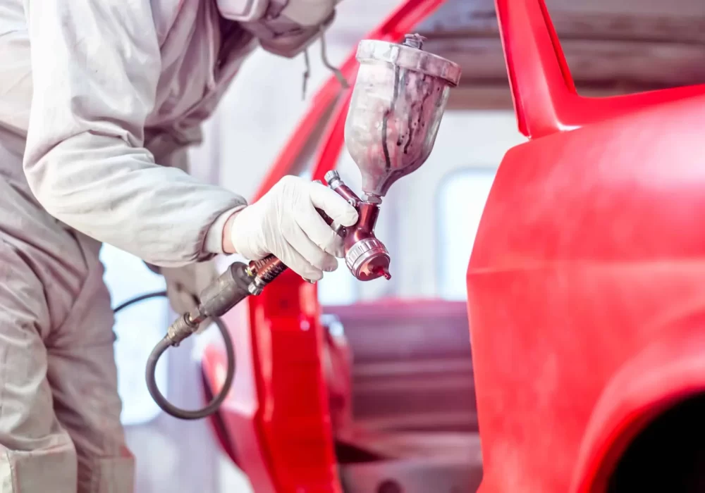 professional-worker-spraying-red-paint-on-a-car-bo-2021-08-26-15-27-59-utc-scaled